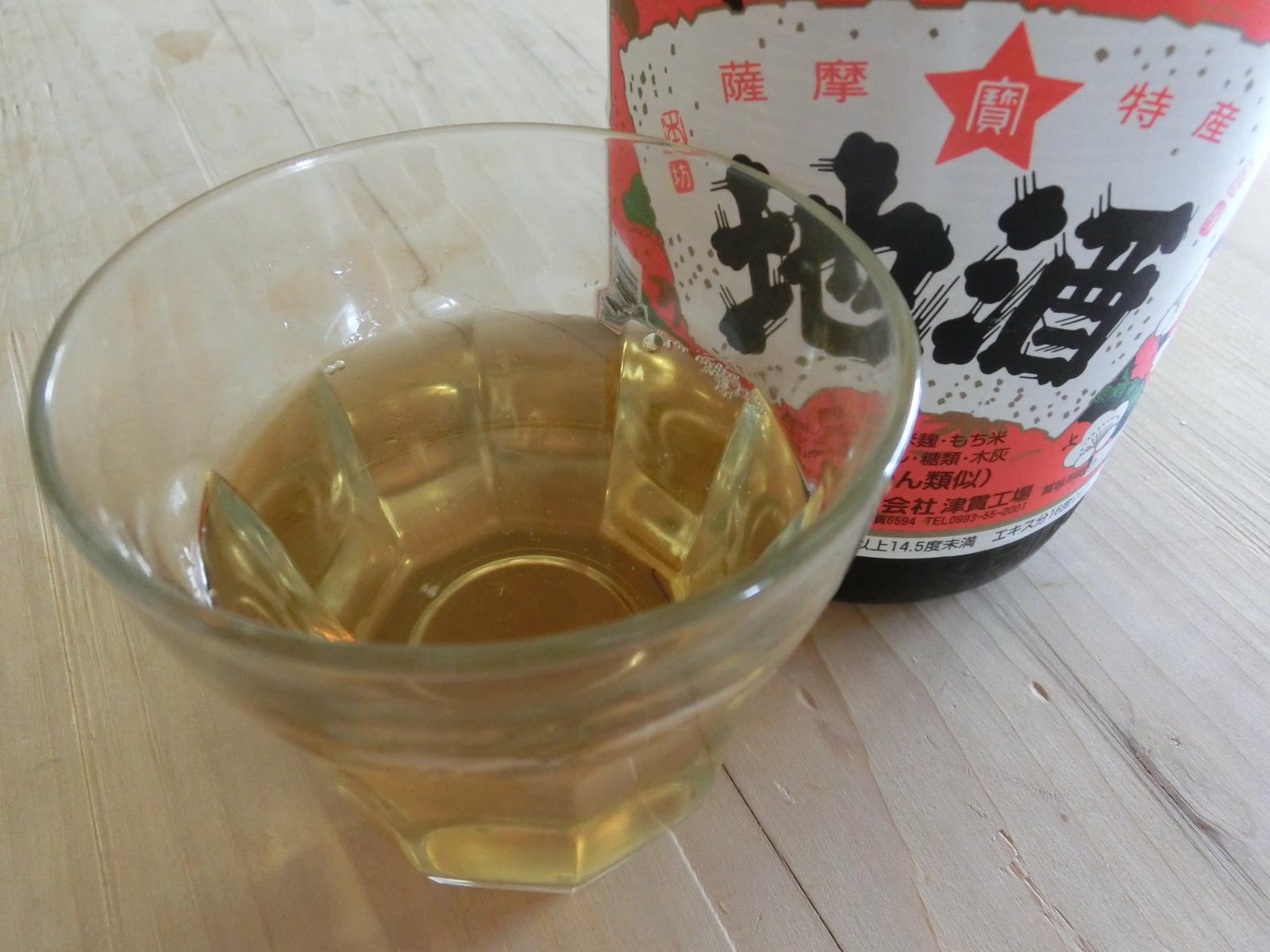 鹿児島の地酒の瓶と、琥珀色の地酒